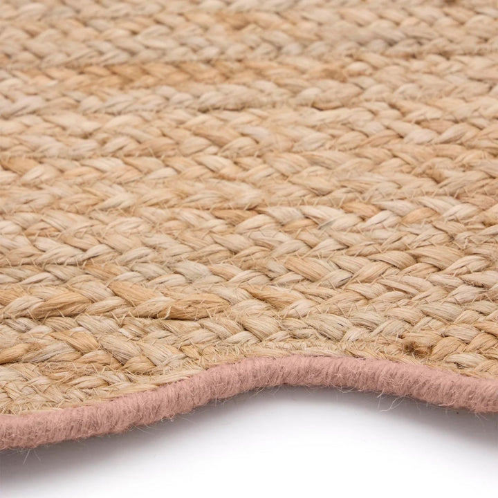 Close-up of a woven natural fiber rug with a pink border on a white background