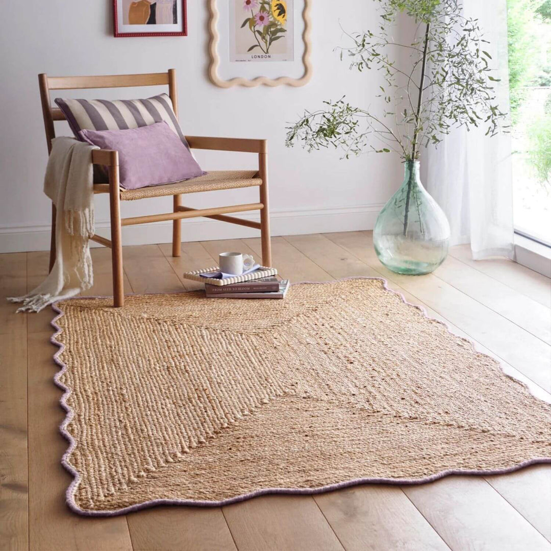 Woven jute rug on a wooden floor with a chair and decorative items.