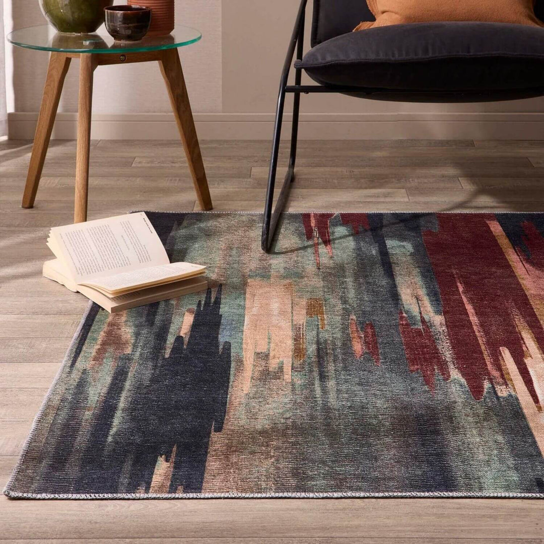 Colorful abstract rug on a wooden floor with a chair and small table in the background.