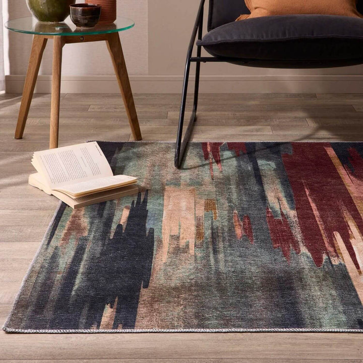 Colorful abstract rug on a wooden floor with a chair and small table in the background.