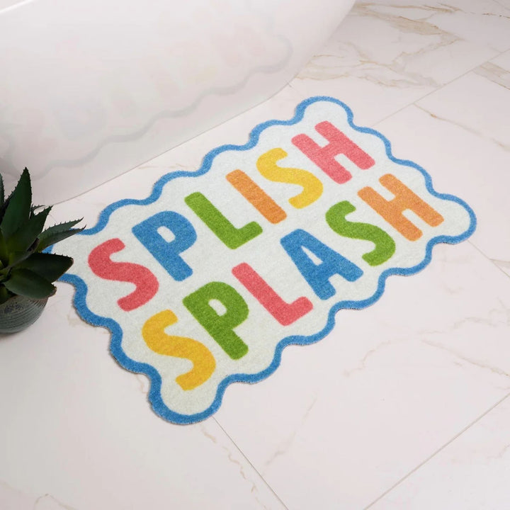 Colorful bath mat with 'Splish Splash' text on a tiled floor.
