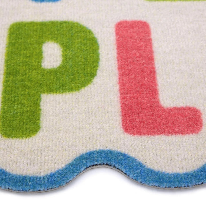 Close-up of a colorful rug with letters 'P' and 'L'.