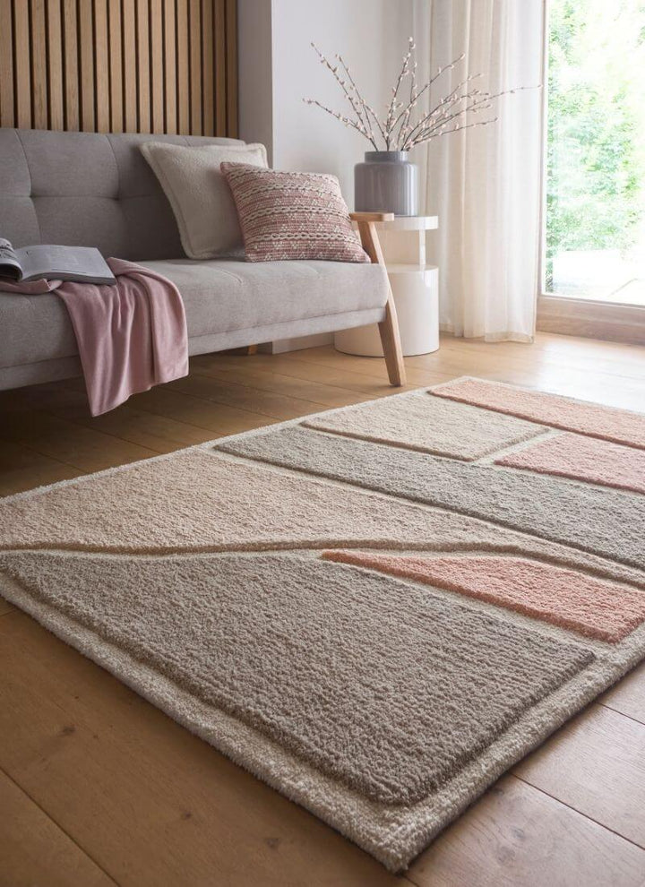 Strata Abstract Rug in soft pink and grey on a wood floor, enhancing modern home decor with texture and style.