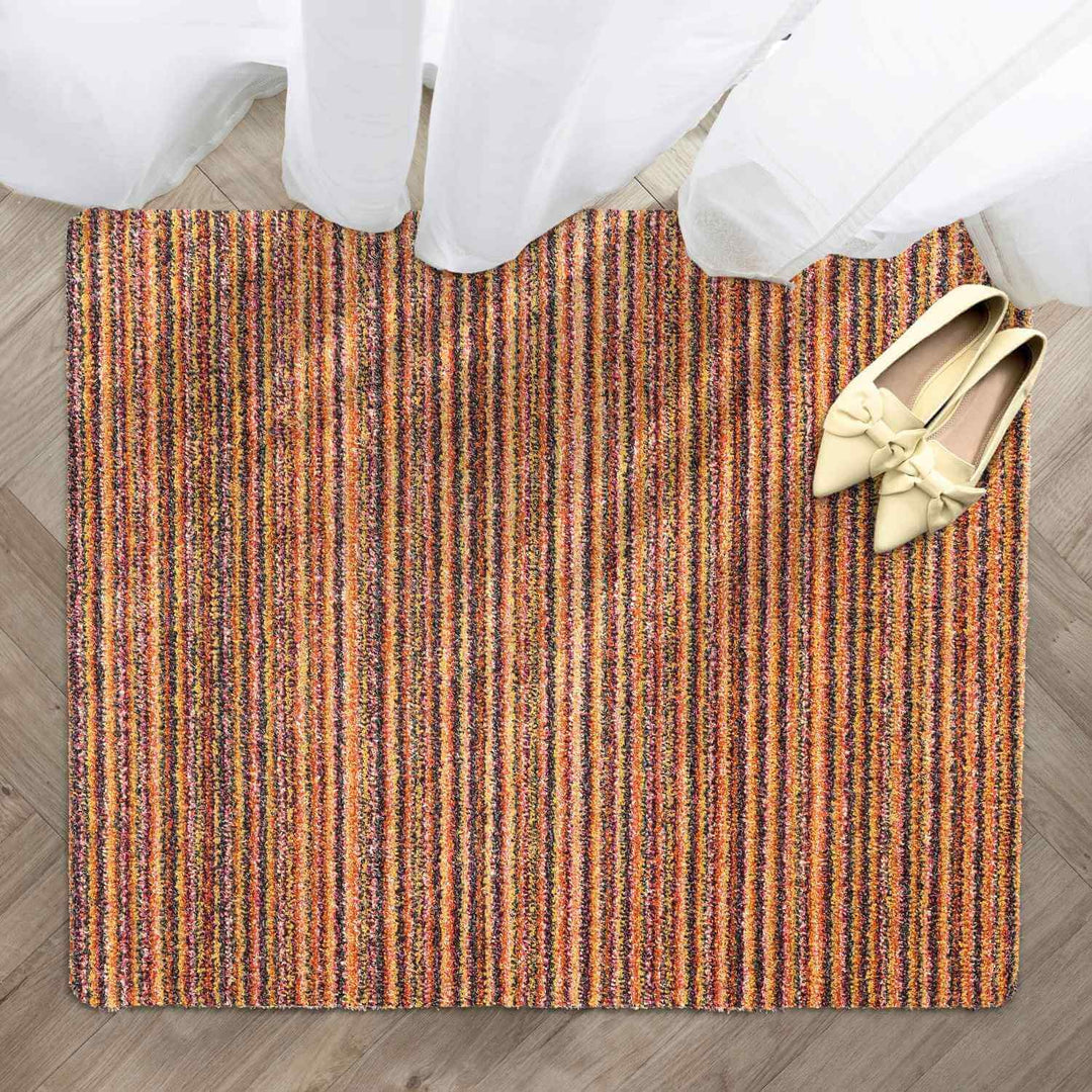 Striped doormat with a pair of shoes on a wooden floor