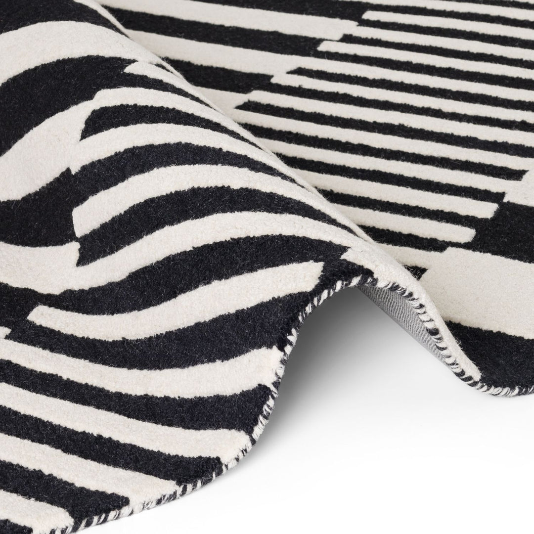 Close-up of a black and white striped rug with a zigzag pattern.