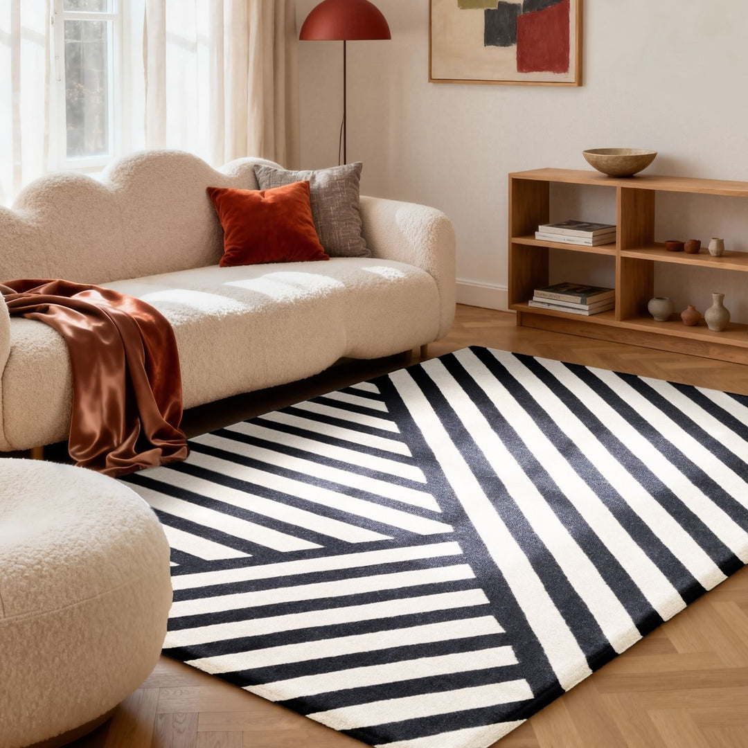 Living room with a black and white striped rug, beige sofa, and wooden shelf.