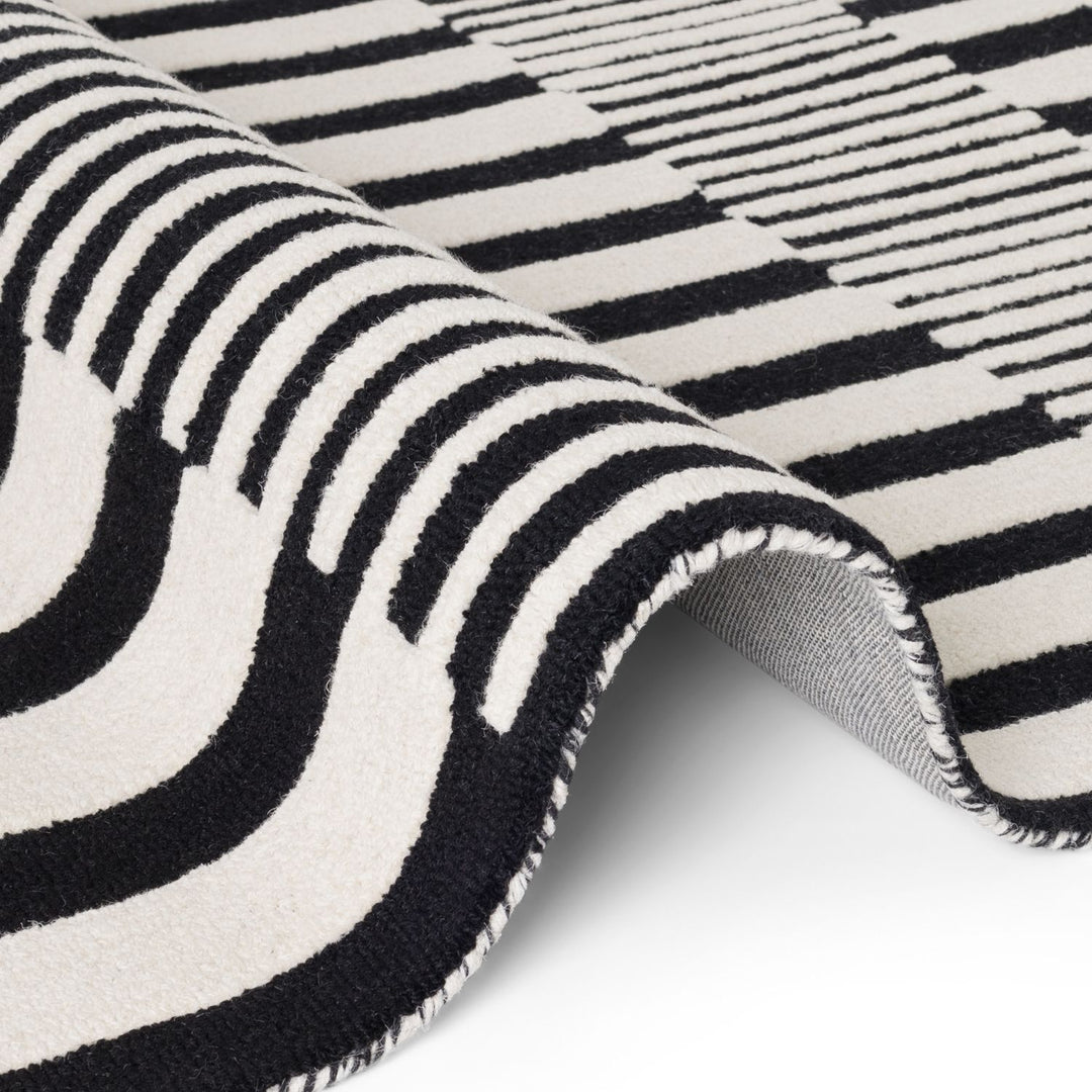 Close-up of a black and white striped rug with geometric patterns.