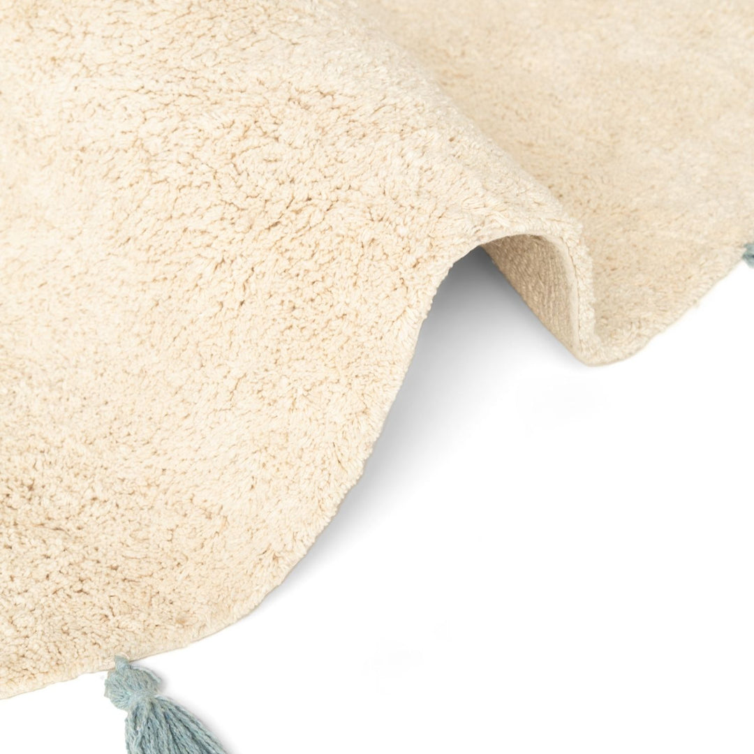 Close-up of a beige textured rug with a tassel on a white background