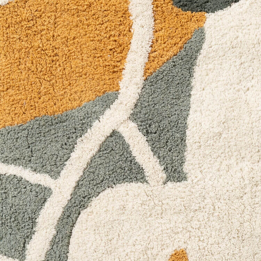 Close-up of a textured rug with geometric pattern in orange, gray, and white.