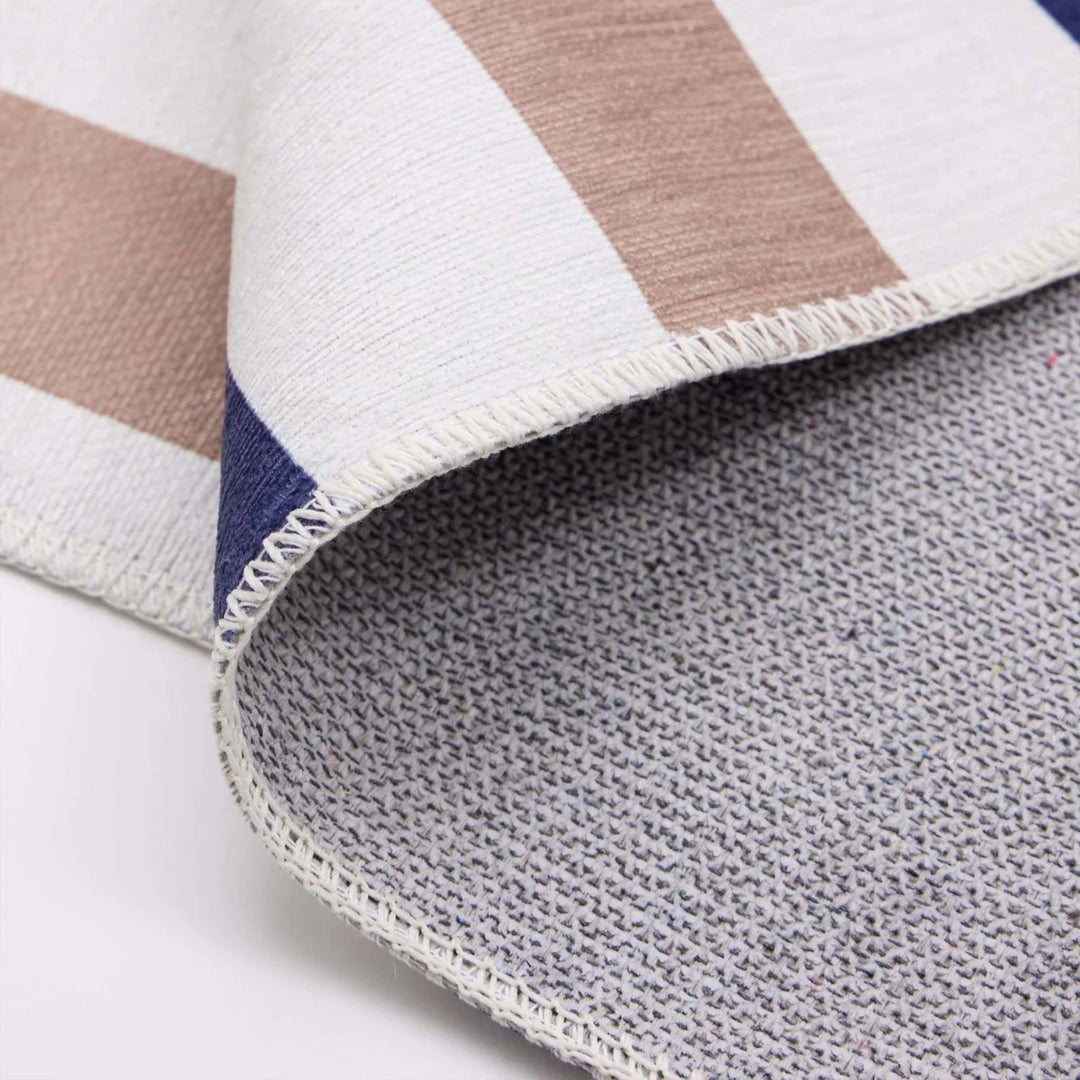 Close-up of a striped fabric with brown, white, and blue colors on a white background.