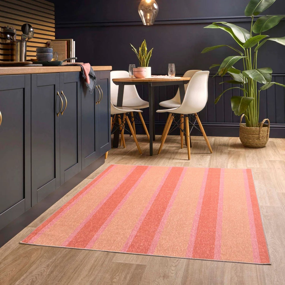 Kitchen with a striped rug on the floor, dining table, and chairs.