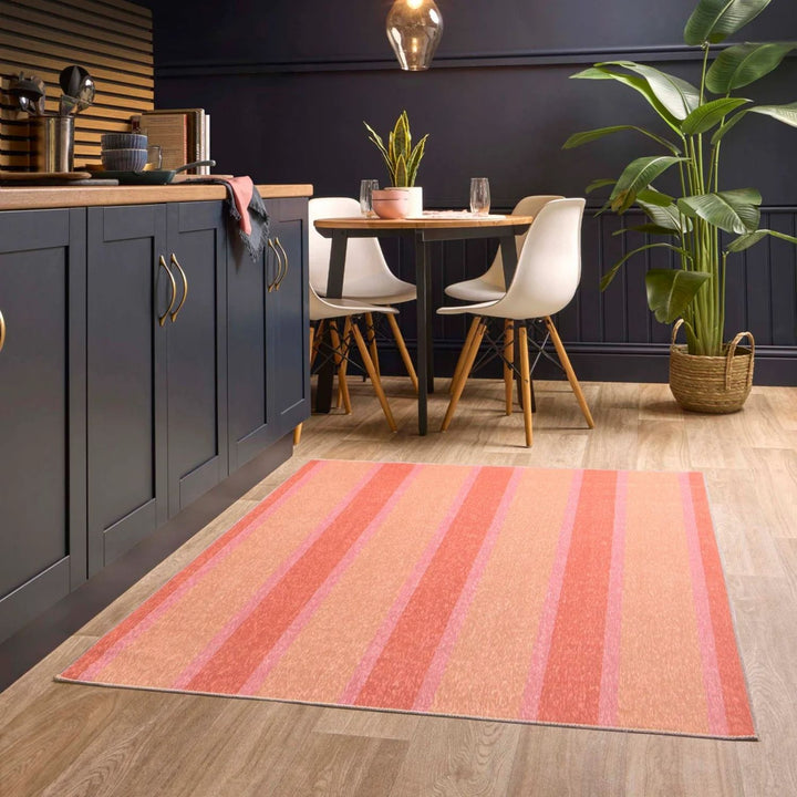 Kitchen with a striped rug on the floor, dining table, and chairs.