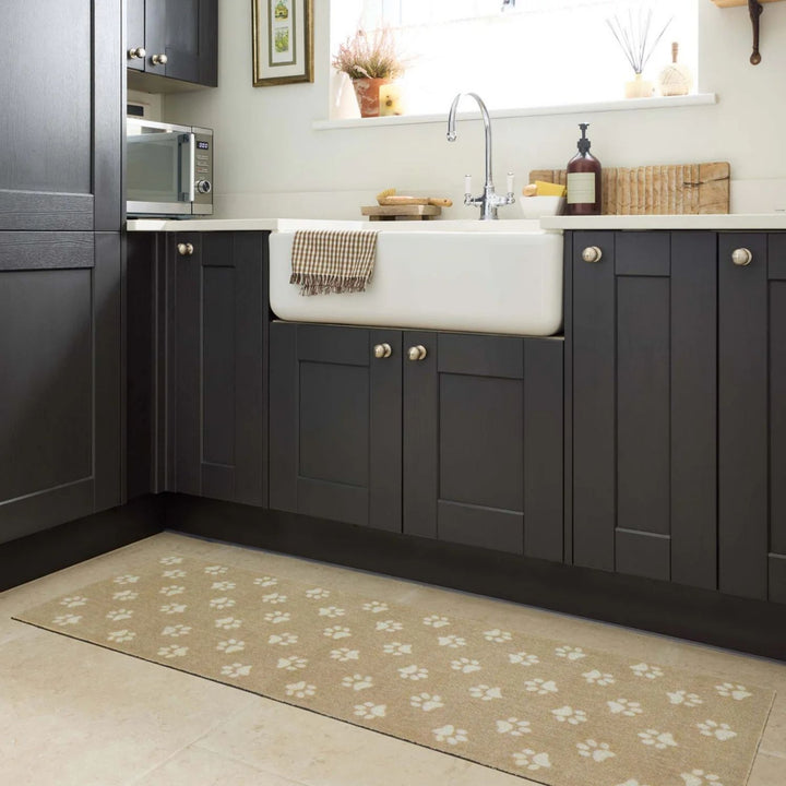 Modern kitchen with dark gray cabinets, white sink, and a patterned rug on the floor.