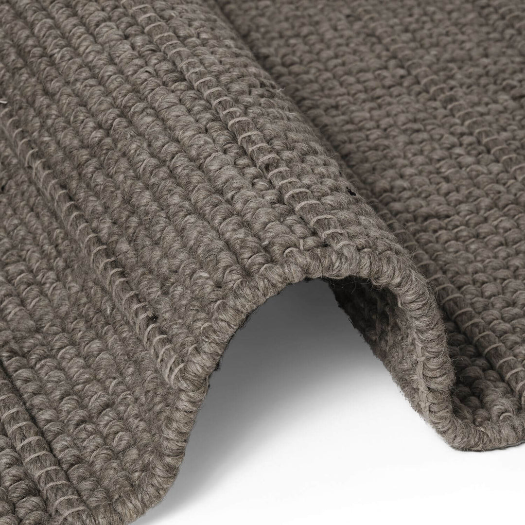 Close-up of a textured brown rug on a white background