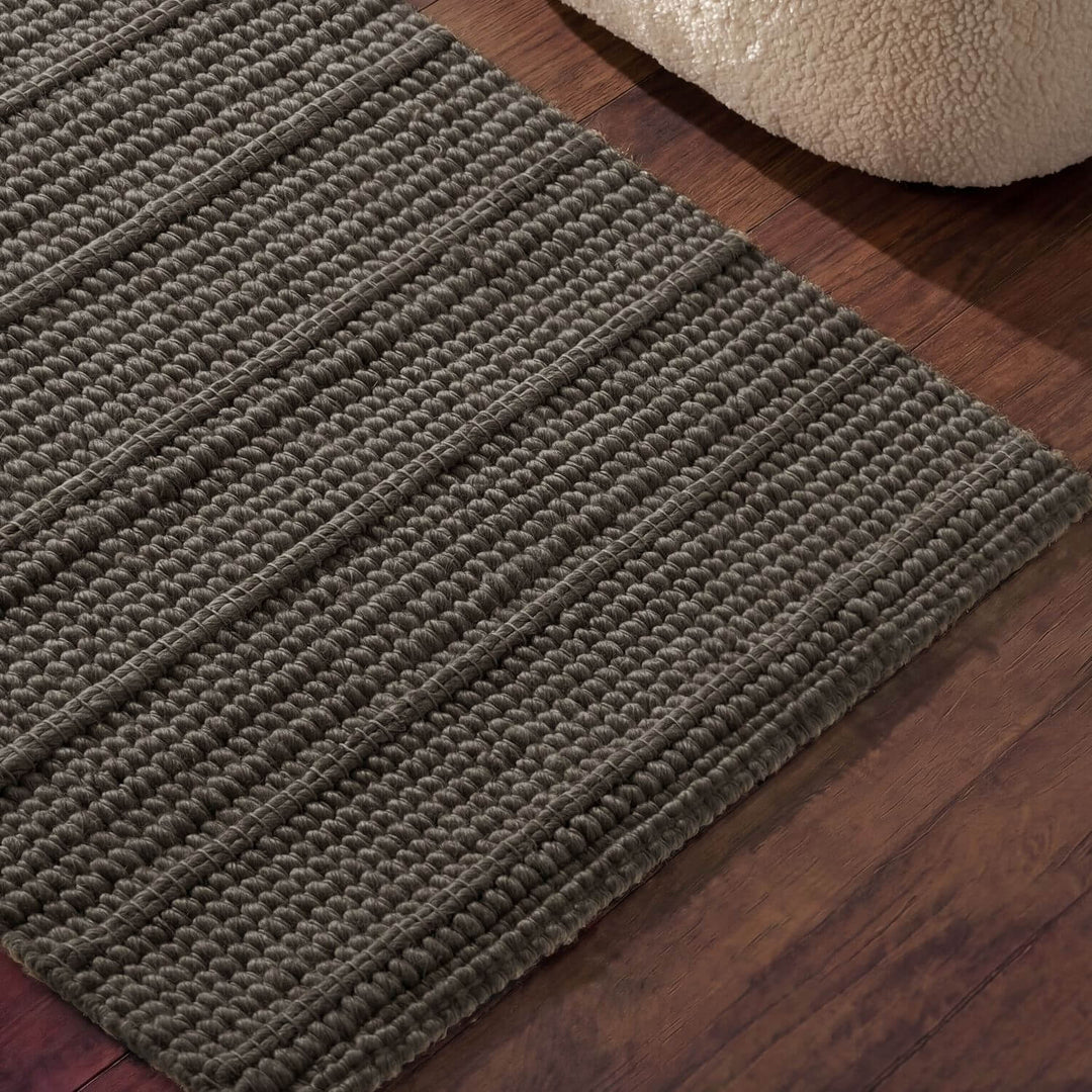 Textured green rug on a wooden floor