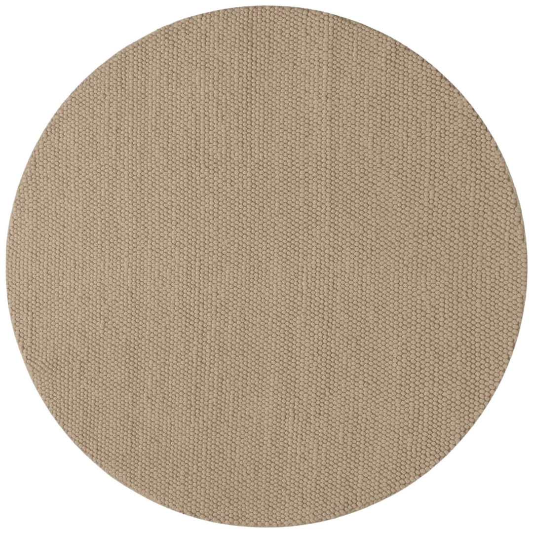 Round beige rug with a textured pattern on a white background