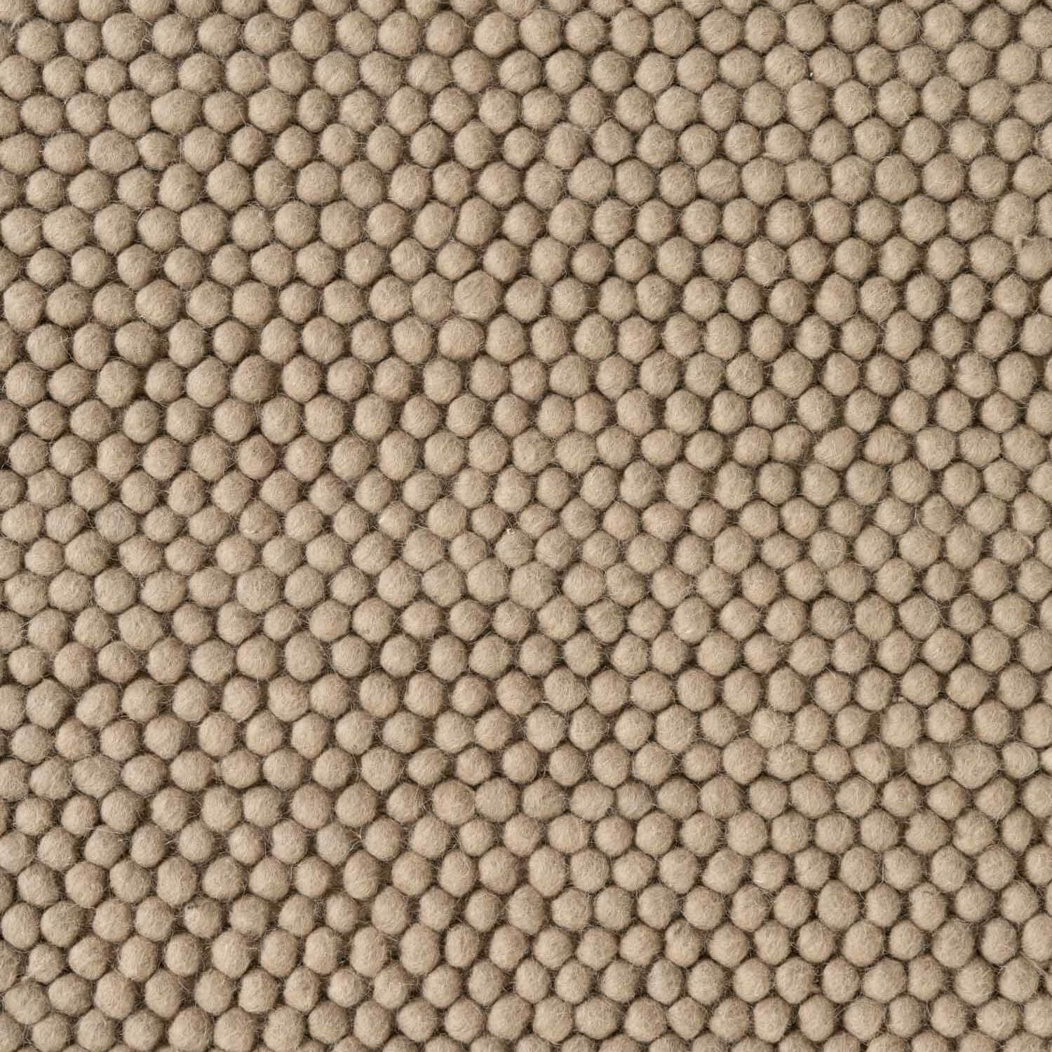 Close-up of beige textured fabric with a honeycomb pattern