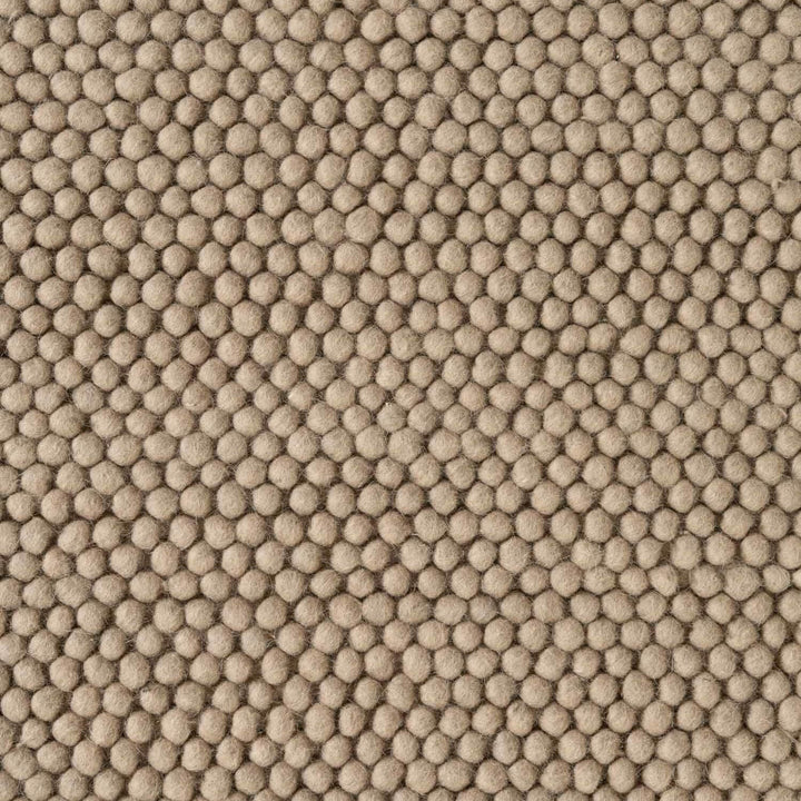 Close-up of beige textured fabric with a honeycomb pattern