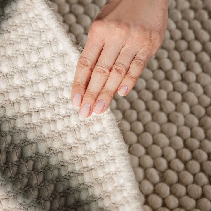 Hand resting on a textured surface with a focus on skin texture and color.