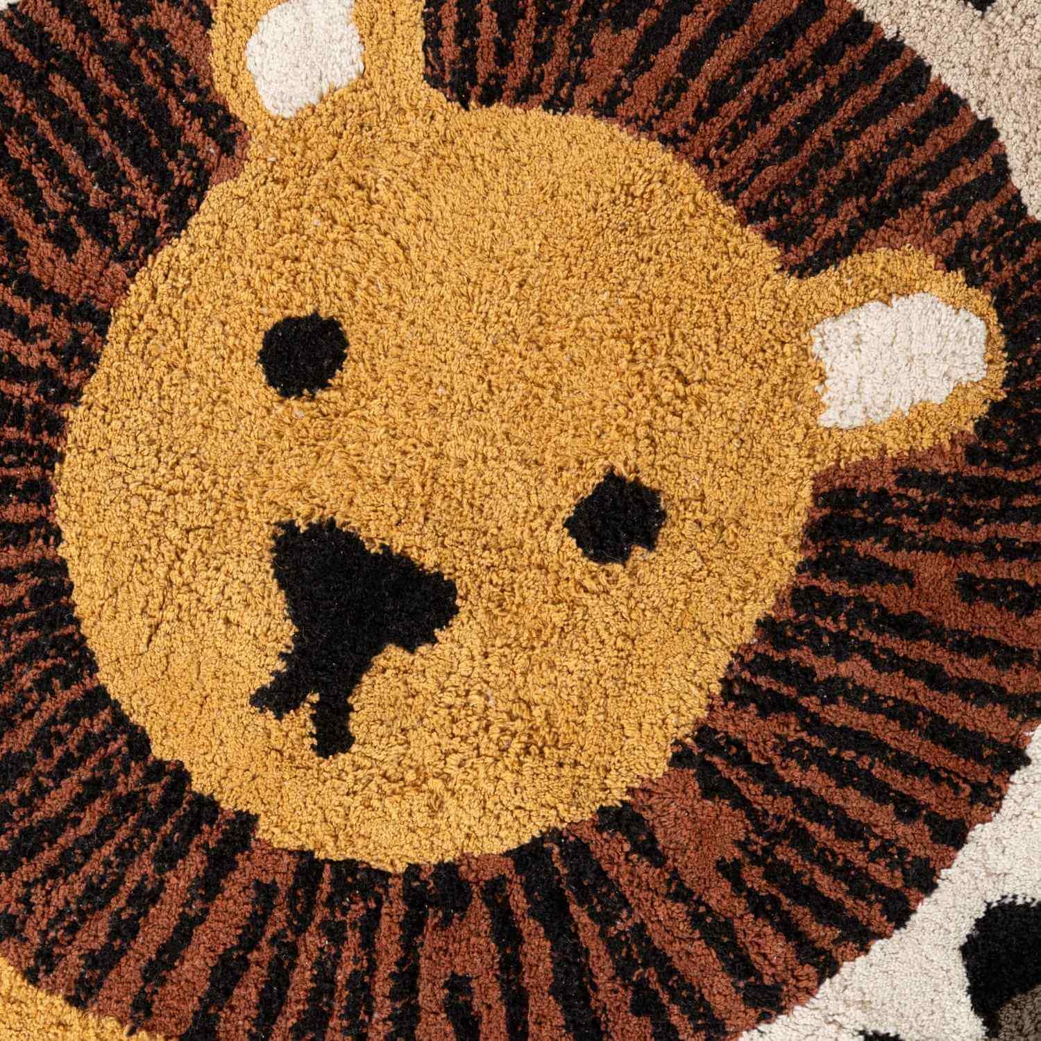 Round rug with a lion face design in brown, black, and beige colors.