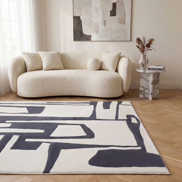 Modern living room with a beige sofa, abstract rug, and abstract painting on the wall.