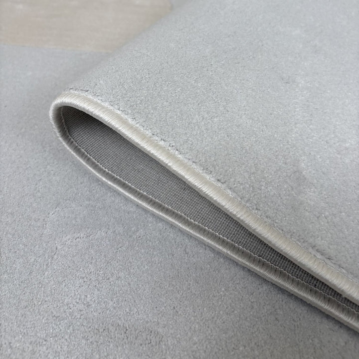 Close-up of a gray rug with a textured border