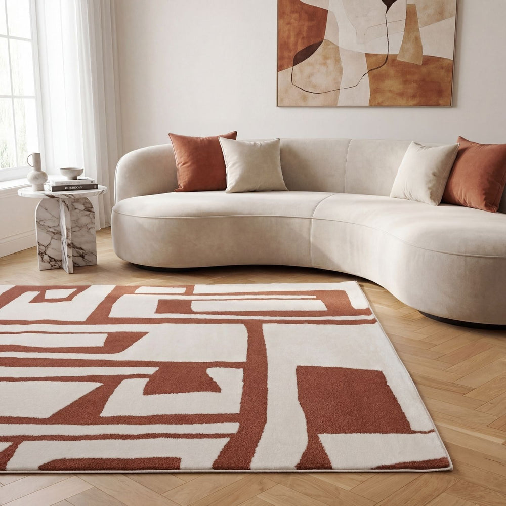 Modern living room with a curved beige sofa, abstract painting, and geometric-patterned rug.