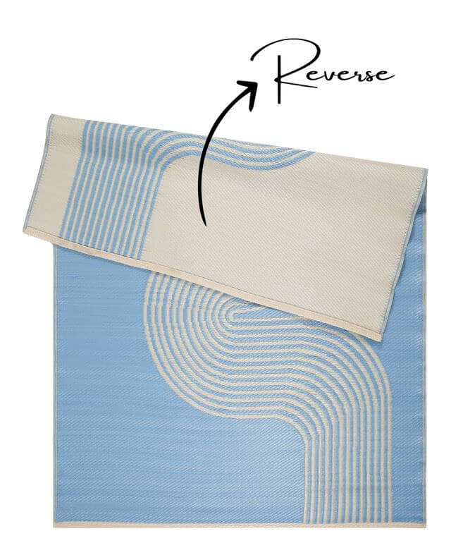 Blue and beige geometric outdoor rug with a reversible design showing both sides.