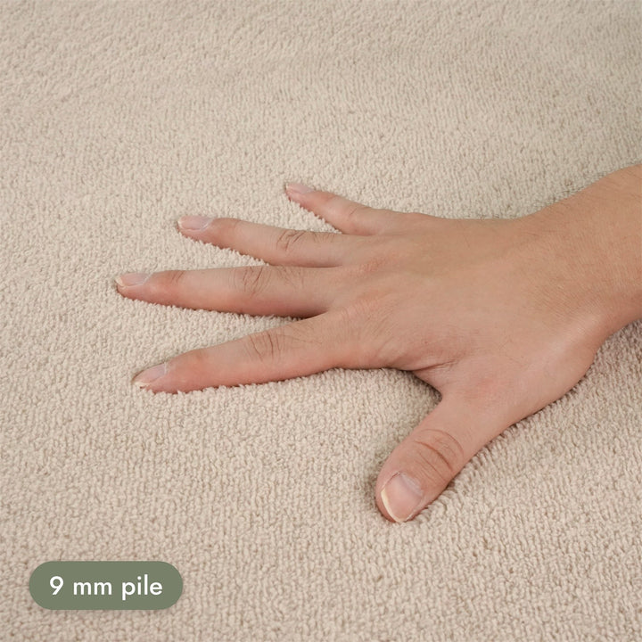 Washmellow beige washable rug, close-up of the soft 9mm pile under a hand | The Rugs