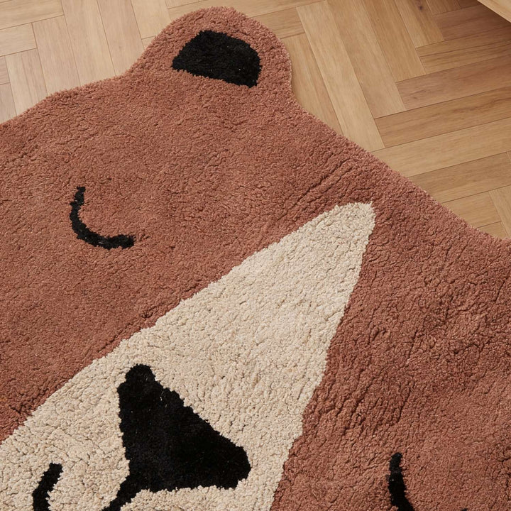 Bear-shaped rug on a wooden floor