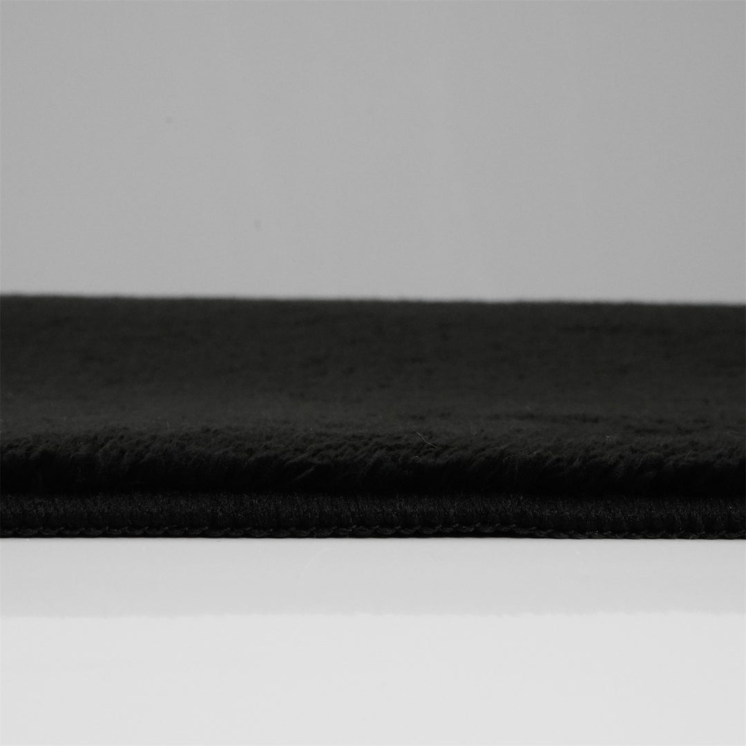 Washmellow black washable rug, side view of the low pile and edge at floor level | The Rugs