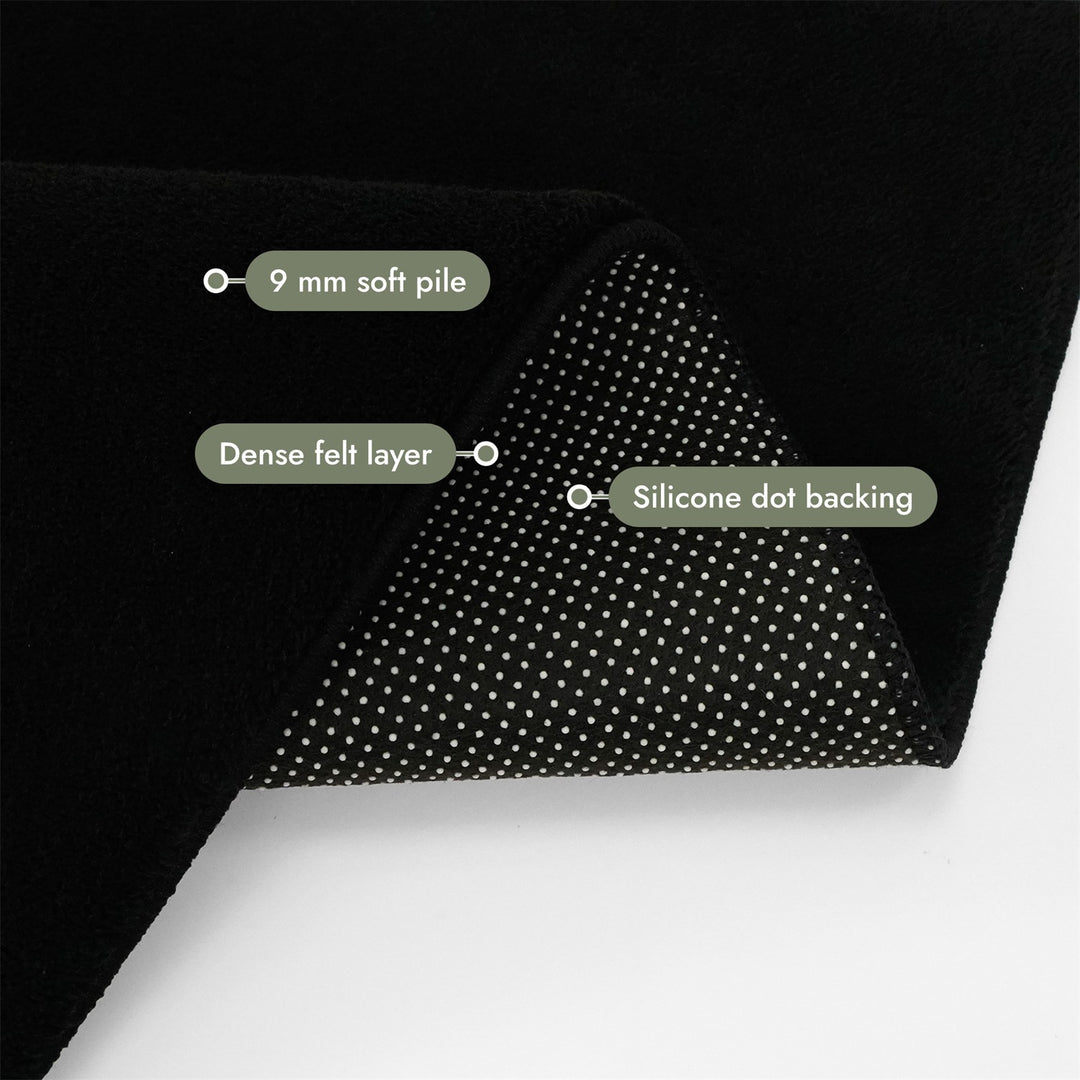 Washmellow black washable rug, folded corner showing the pile, felt layer and backing | The Rugs