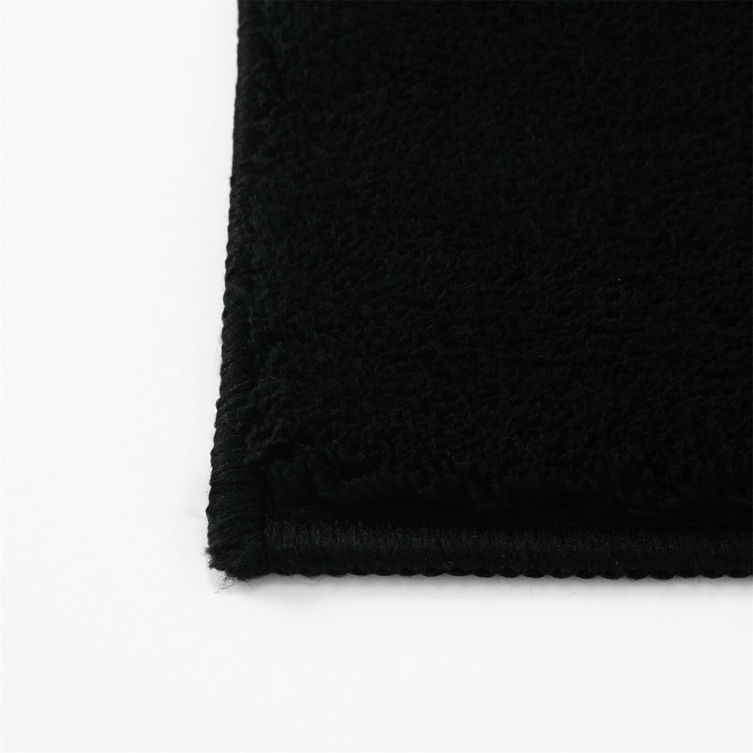 Washmellow black washable rug, close-up of the corner and bound edge | The Rugs