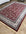 Decorative red and white patterned rug on a wooden floor