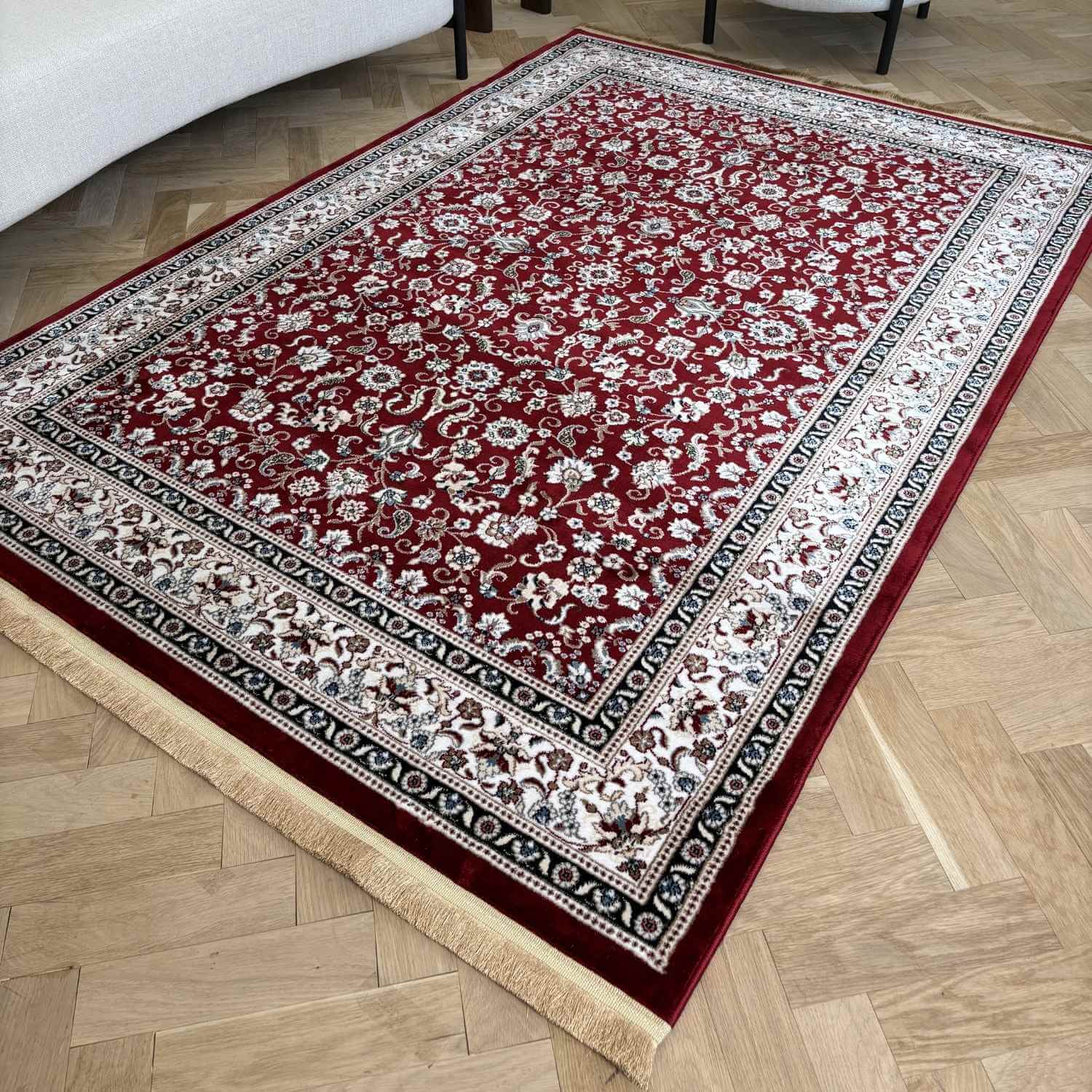 Decorative red and white patterned rug on a wooden floor
