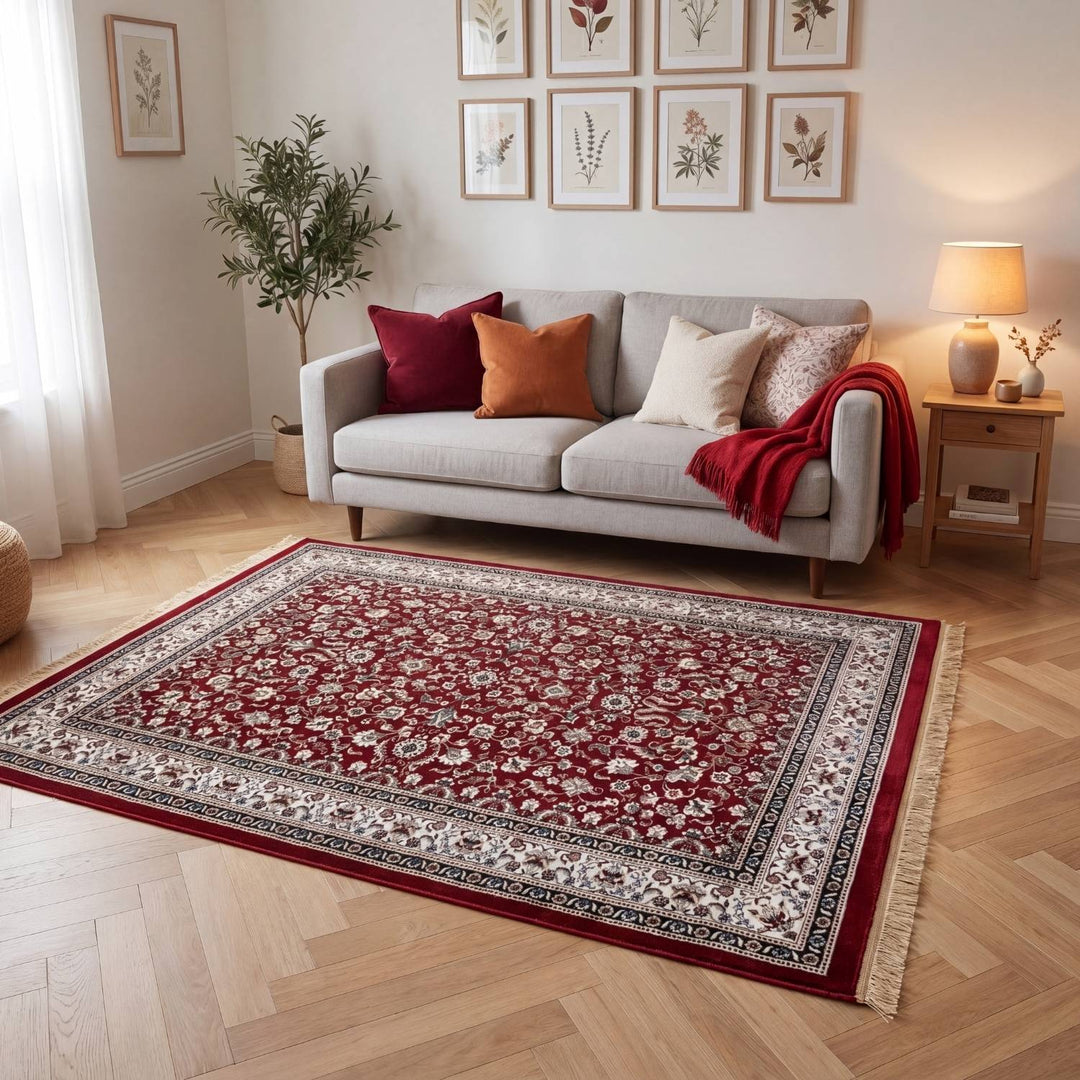 Living room with a red patterned rug, gray sofa, and decorative pillows.