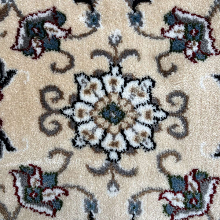 Close-up of a patterned rug with floral designs on a beige background