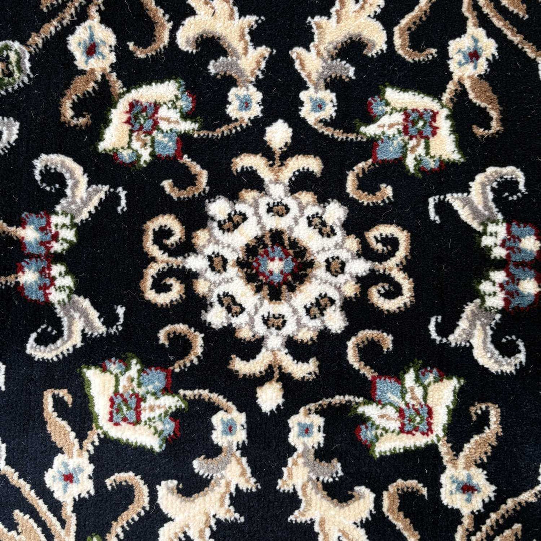Close-up of an intricate embroidered pattern on fabric with a black background.