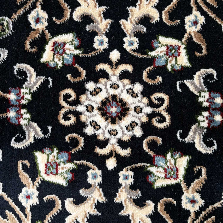 Close-up of an intricate embroidered pattern on fabric with a black background.