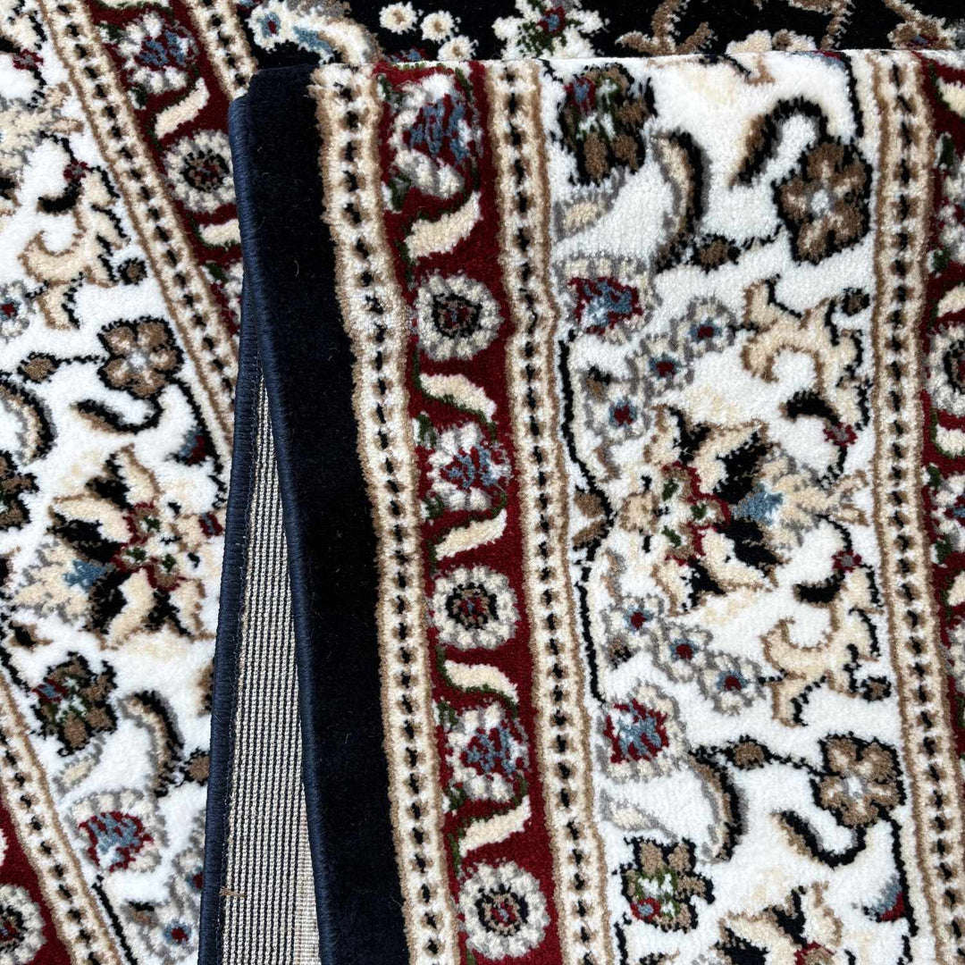 Close-up of a patterned rug with a black object on top