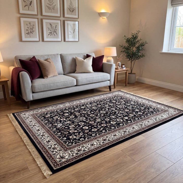 Living room with a patterned rug, gray sofa, and framed pictures on the wall.