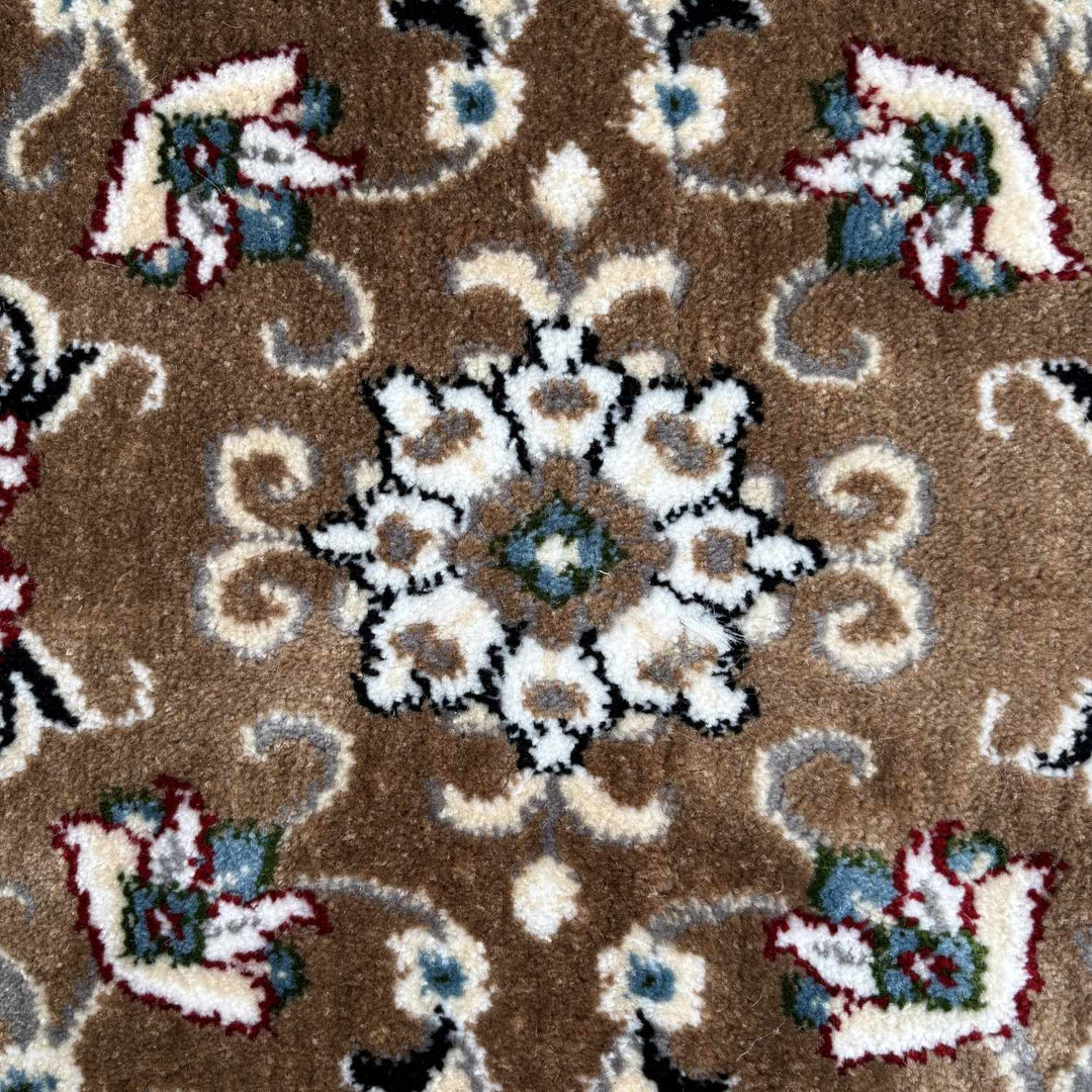 Close-up of a patterned rug with floral designs on a brown background