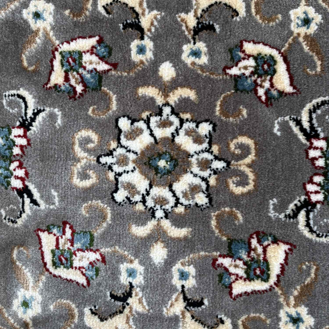 Patterned rug with floral and paisley designs on a gray background