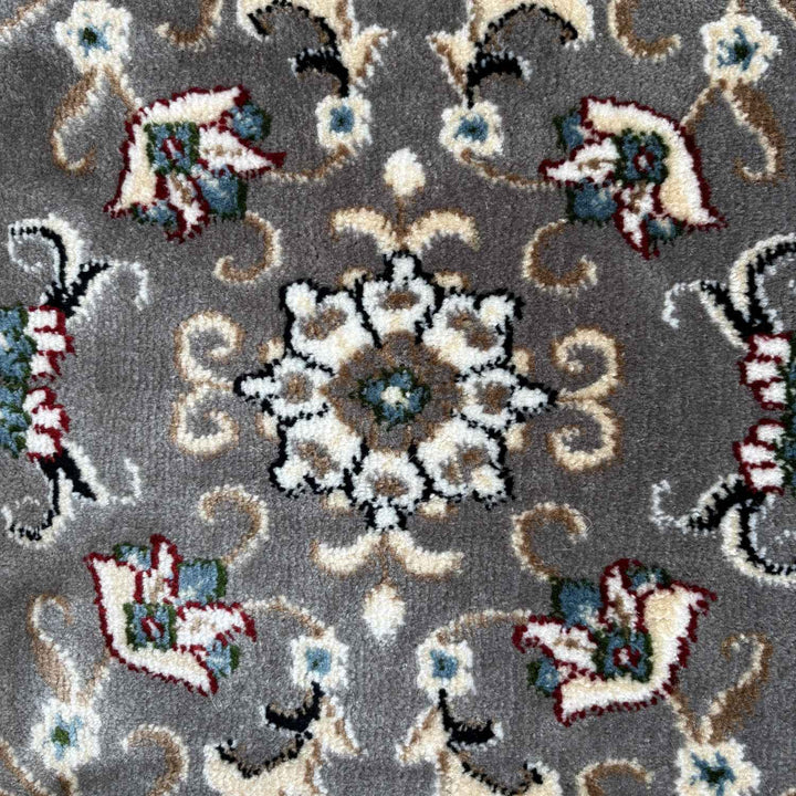 Patterned rug with floral and paisley designs on a gray background