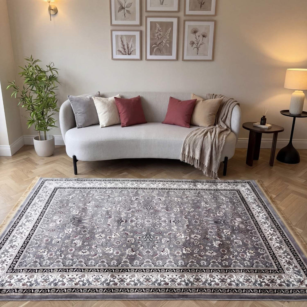 Living room with a decorative rug, sofa, and wall art.