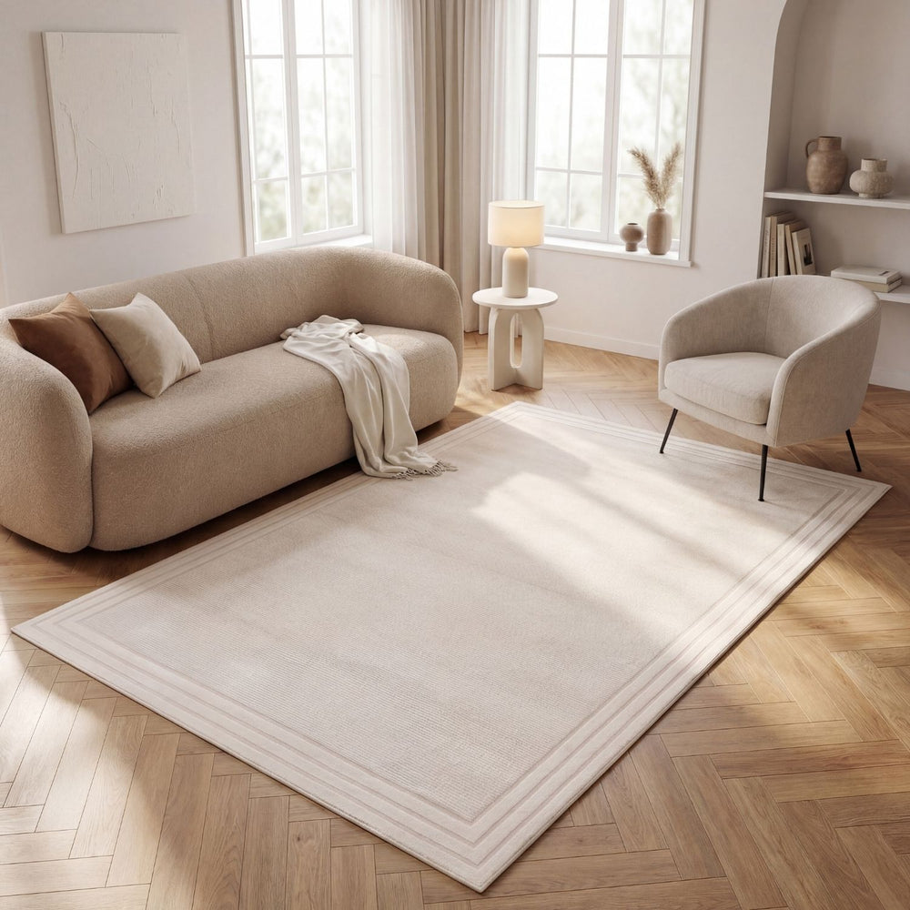 Modern living room with beige sofa, armchair, and white rug on wooden floor.