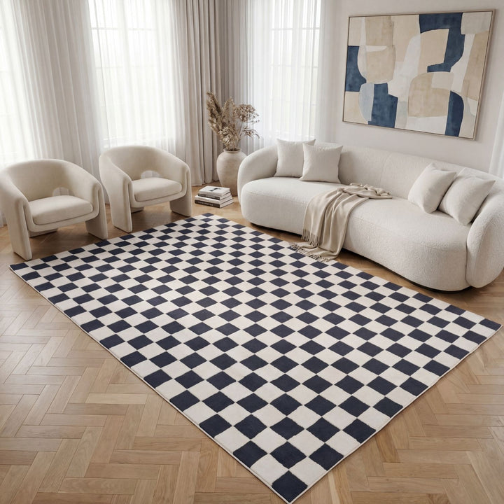 Living room with a checkered black and white rug, beige sofa, and armchairs.