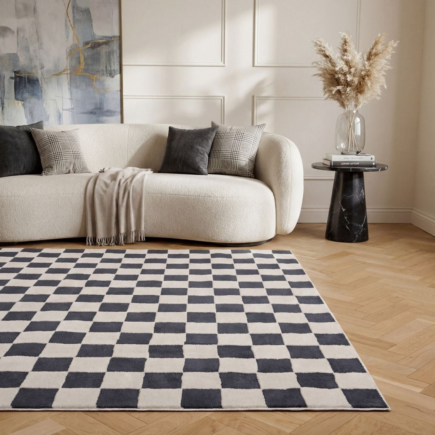 Living room with a checkered rug, beige sofa, and abstract art on the wall.