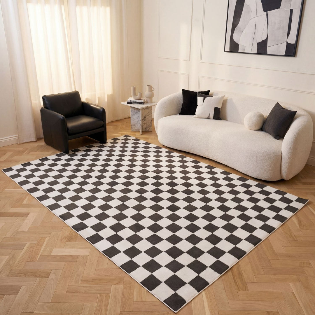Living room with a checkered black and white rug, white sofa, and black armchair.