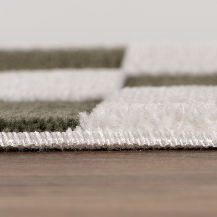 Close-up of a textured rug with a neutral color palette on a wooden floor.